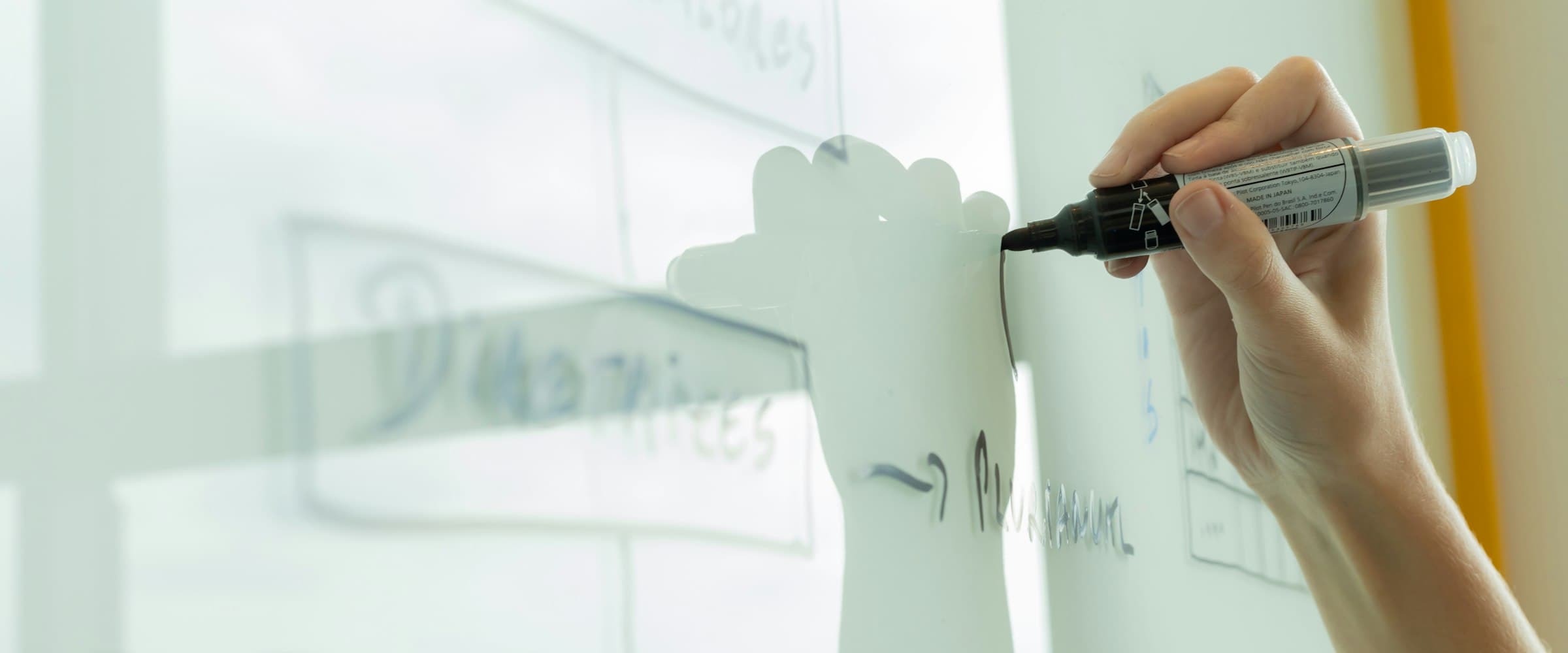Hand drawing an organizational diagram on a whiteboard